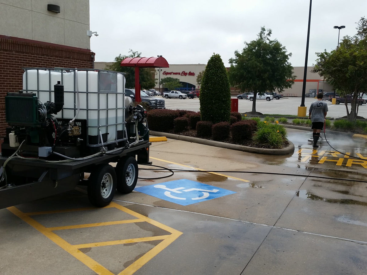 Mobile wash trailer cleaning a parking lot and accessible parking spaces
