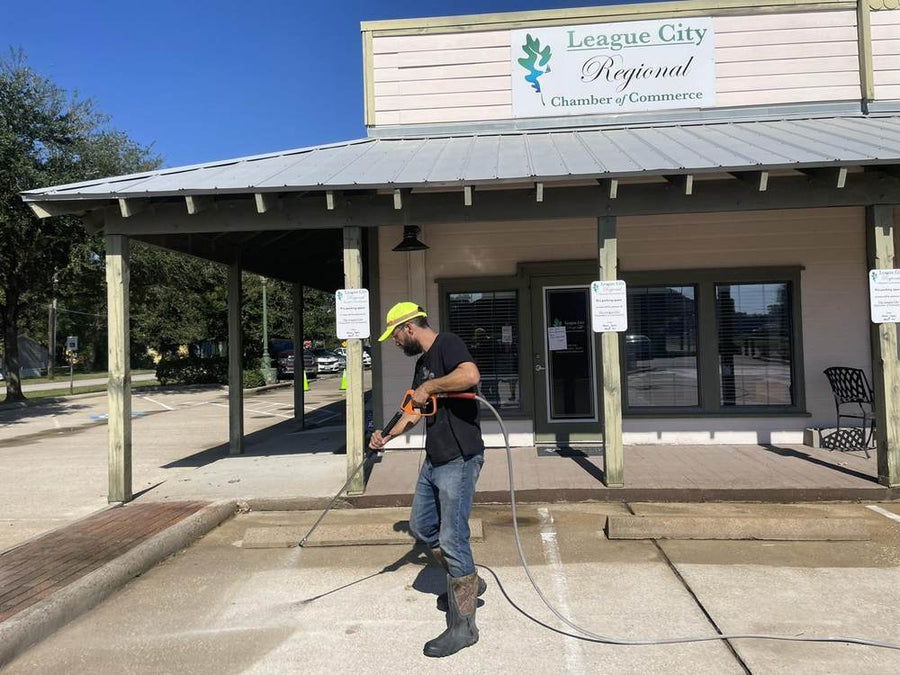 Texas Commercial Wash cleaning the League City Regional Chamber of Commerce storefront, parking lot, and sidewalks.