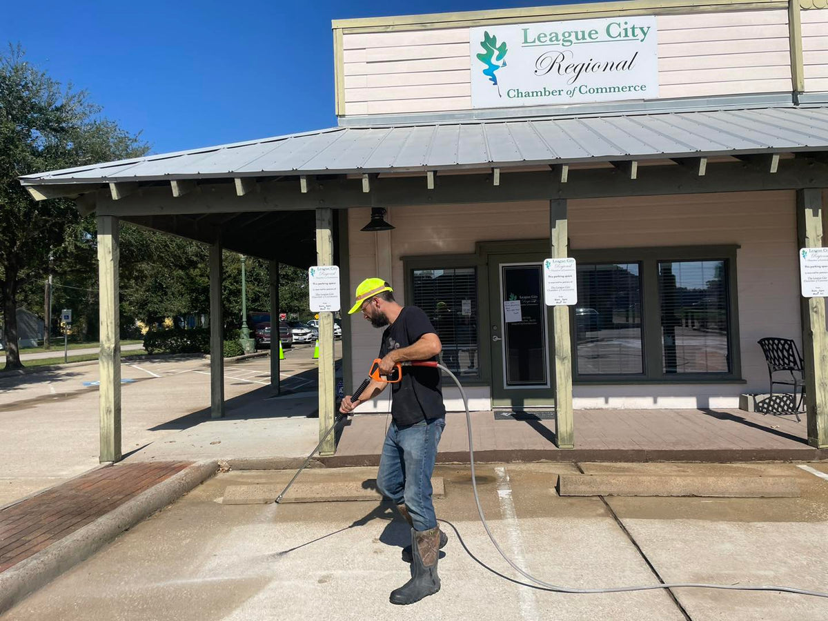 Texas Commercial Wash cleaning the League City Regional Chamber of Commerce storefront, parking lot, and sidewalks.